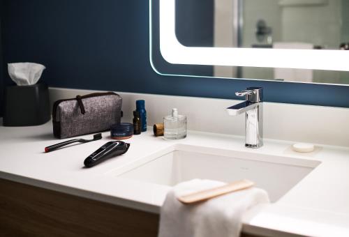 a bathroom with a sink and a mirror at Hyatt Studios Texarkana in Texarkana