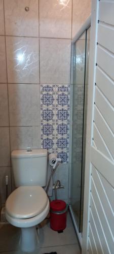 a bathroom with a toilet and a glass shower at Suite em Lumiar in Lumiar