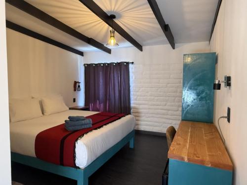 a bedroom with a bed and a table in a room at Ckoinatur Hostel in San Pedro de Atacama