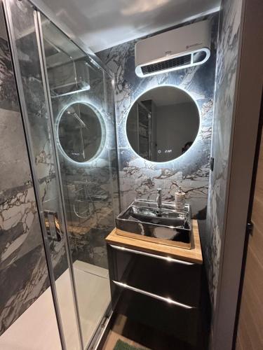 a bathroom with a sink and a shower with a mirror at Studio zen climatisé piscine parking in Balaruc-les-Bains