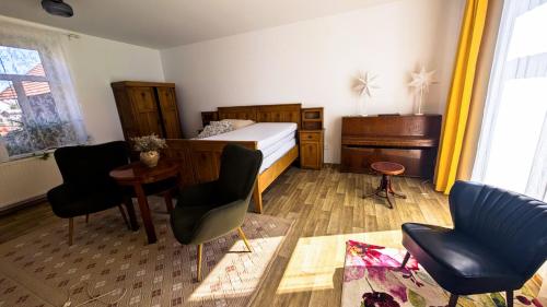 a bedroom with a bed and two chairs and a desk at Statek Osmička in Dolní Hořice