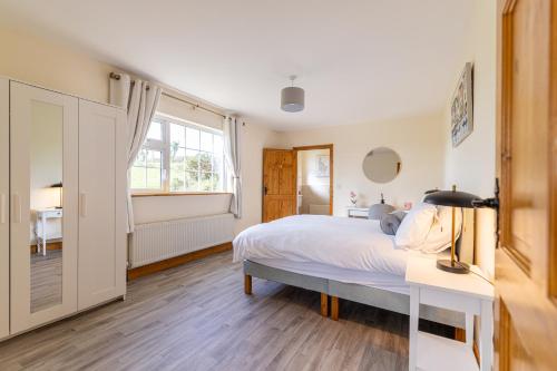 a bedroom with a bed and a desk and a window at Hillside House - Rose Cottage in Ballinamuck