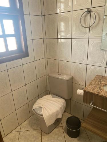 a white bathroom with a toilet and a window at Hotel Sara - Ampere in Ampère
