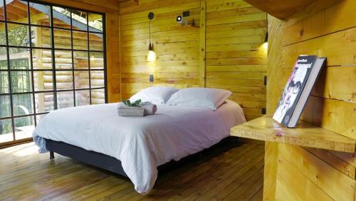 a bedroom with a bed in a wooden cabin at Cabaña Silencio en Casa Ilusión in Guarne