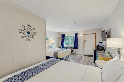 a hotel room with two beds and a desk at Lamplighter Inn - 115 Turtle Bay in Bandon
