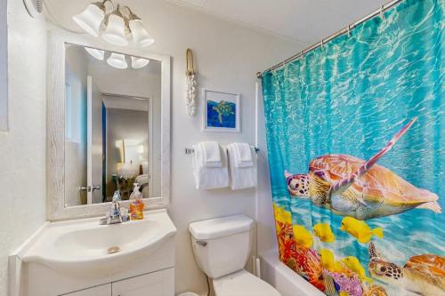 a bathroom with a shower curtain with a fish on it at Lamplighter Inn - 115 Turtle Bay in Bandon