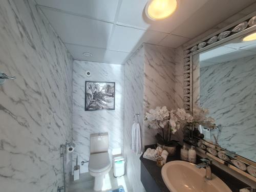 a bathroom with a sink and a toilet and a mirror at Belstay2 in Ras al Khaimah