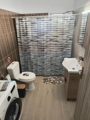 a bathroom with a toilet a sink and a shower at Avocado house in Finikounta