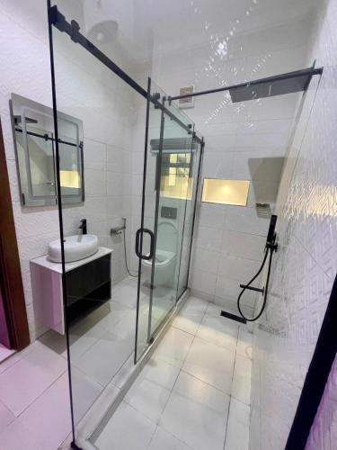 a bathroom with a glass shower and a sink at Luxury Four Bedroom Duplex in Asokoro Abuja in a Secure Estate with Fast WiFi & 24hours Electricity in Asokoro