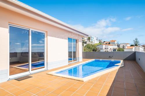 a swimming pool in the backyard of a house at Funchal Bay View Villa by Homie in Funchal