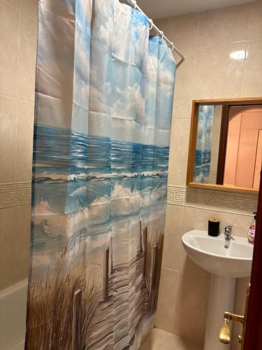 a bathroom with a shower curtain with the ocean at Apartamentos Amy 3 con vista a mar in Palos de la Frontera