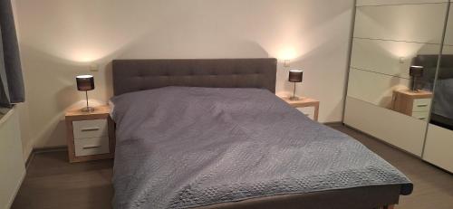 a bedroom with a large bed with two night stands at Tisovecký apartmán in Tisovec