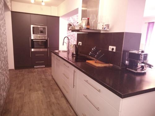 a kitchen with a black counter top and an oven at Tisovecký apartmán in Tisovec