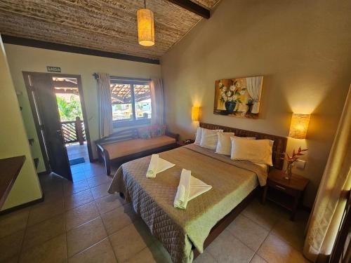 a hotel room with a bed and a chair at Hotel Pousada Imbassai in Imbassai