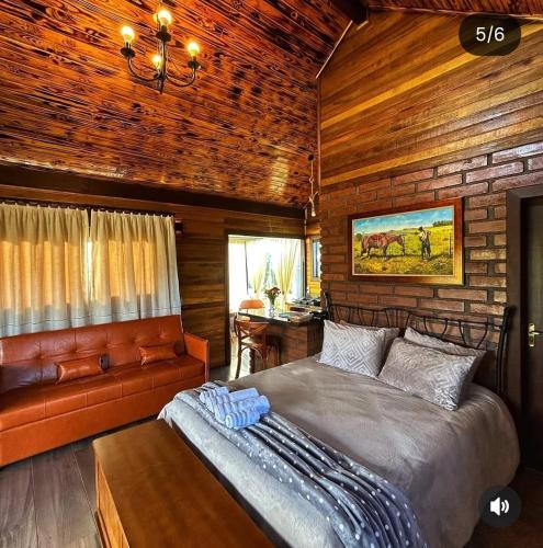 a bedroom with a bed and a couch at Cabana Davos in Timbe do Sul