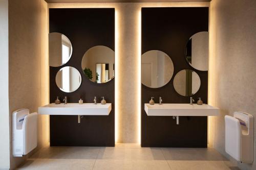 a bathroom with two sinks and mirrors on the wall at Badiula in Carlentini