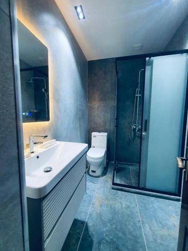 a bathroom with a sink and a shower and a toilet at Volidam Hotel in Qarshi
