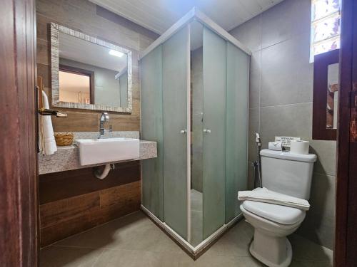 a bathroom with a toilet and a sink and a shower at Hotel Pousada Imbassai in Imbassai
