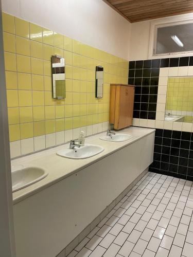 a public bathroom with two sinks and two mirrors at Sikhall Camping & Restaurang in Sörbo