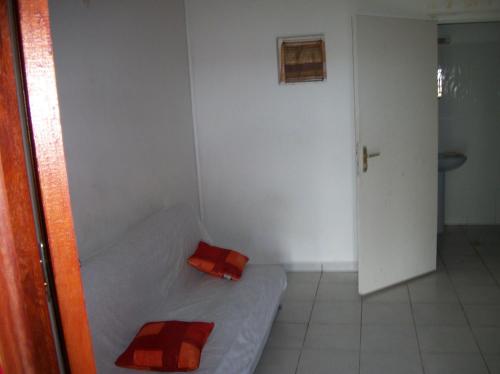 a small room with a bed and a door at Bellevue Studios in Mare Gaillard
