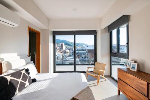 a bedroom with a bed and a large window at 105 Downtown cerca de playa y el malecón in Puerto Vallarta
