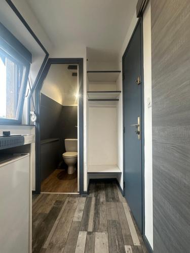a small bathroom with a toilet and a door at California in Maretz