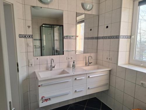 a bathroom with two sinks and a mirror at Familienwohnung Emprechting in Emprechting