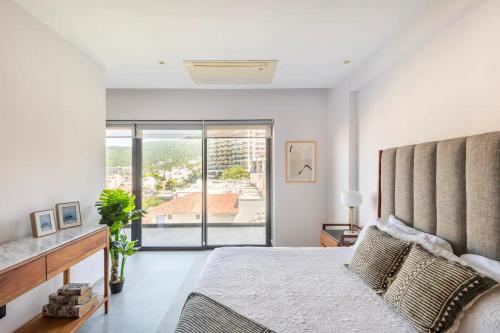 a bedroom with a large bed and a large window at Zona romantica cerca del muelle los muertos in Puerto Vallarta