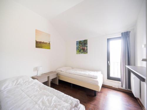 a white bedroom with a bed and a window at Hambachtal nature hideaway boutique resort in Oberhambach