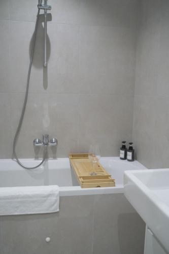 a bathroom with a bath tub with a shower and a sink at Modernes Apartment in Schwechat in Schwechat
