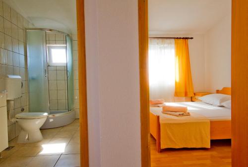 a bedroom with a bed and a bathroom with a toilet at Apartment Mara in Primošten