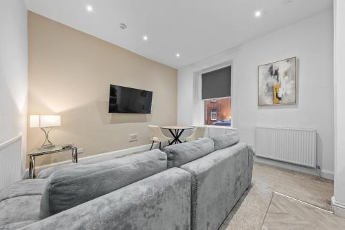 a living room with a couch and a tv at Loch Lomond Retreat in Bonhill