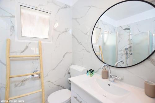 a bathroom with a mirror and a sink at וילה ארבל in Kefar Weradim