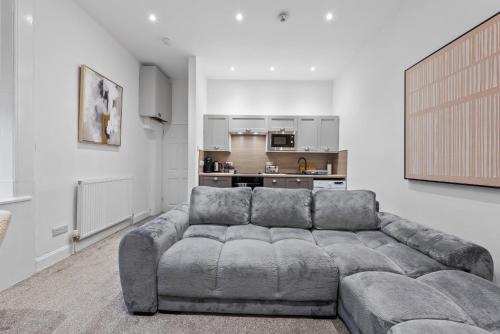a living room with a couch and a kitchen at Loch Lomond Retreat in Bonhill