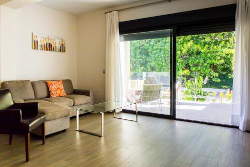 a living room with a couch and a glass table at BLUESEA Dimona Suites in Torremolinos