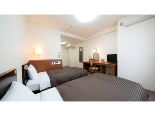 a hotel room with two beds and a desk at Royal Hotel Uohachi - Vacation STAY 71045v in Toyota