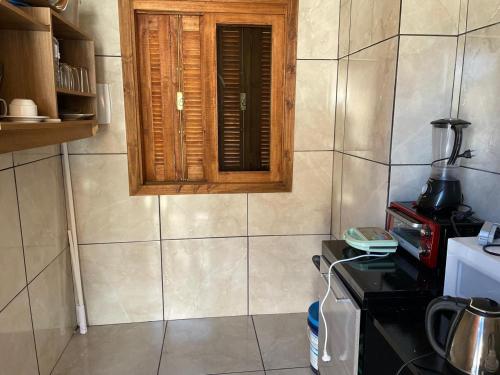 a small kitchen with a window and a stove at Vale de Cambara in Cambará