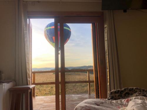 a bedroom with a view of a hot air balloon at Vale de Cambara in Cambará
