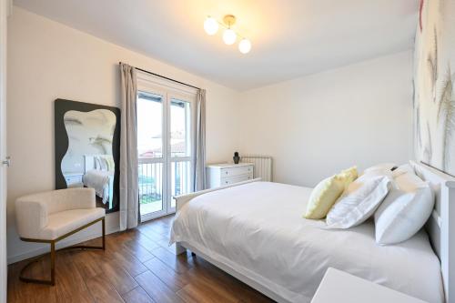 a white bedroom with a bed and a chair at Lora Luxury Suite 6 ,free private parking, self check in, air conditioner in Como