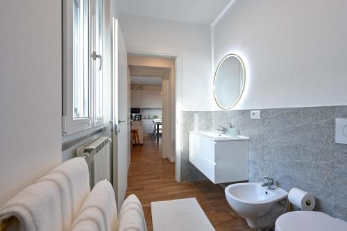 a white bathroom with a sink and a mirror at Lora Luxury Suite 6 ,free private parking, self check in, air conditioner in Como
