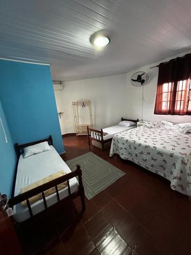 a bedroom with two beds and a blue wall at Refugio Caiçara in Cananéia