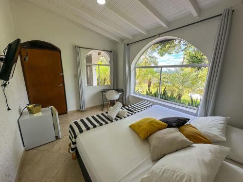 a bedroom with a large bed with a large window at Amara Hotel in Doradal