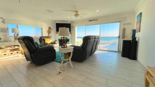 a living room with two chairs and a table at Cozy & Colorful Beachfront Condo Las Olas I 28 in Puerto Peñasco