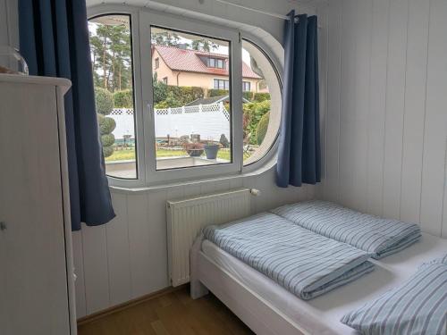 a small bed in a room with a window at Charmanter Bungalow in Neubukow nahe der Ostsee in Neubukow