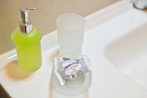 a sink with a bottle and a soap dispenser on it at Lucia's Apartments in Ischia Town