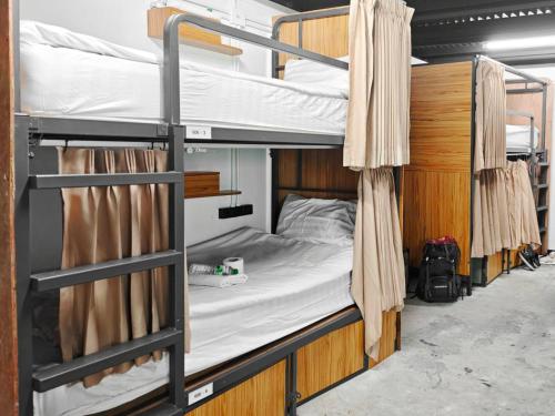 a couple of bunk beds in a room at Sleep Owl Jomtien in Jomtien Beach