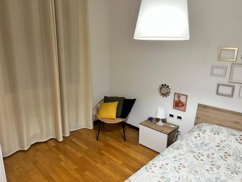 a bedroom with a bed and a chair with a yellow pillow at Iris in Montecchio Maggiore