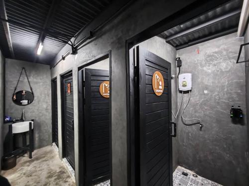 a bathroom with two black doors and a sink at Sleep Owl Jomtien in Jomtien Beach