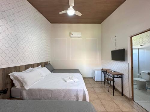 a bedroom with a bed and a bathroom with a television at Espaço Malongo in Sarzedo