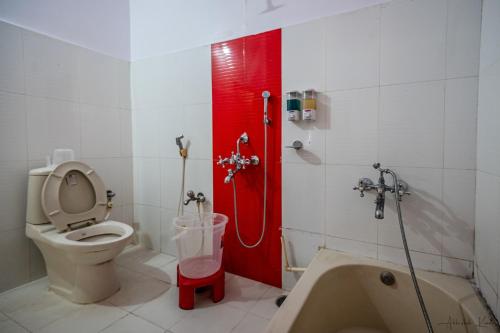 a bathroom with a toilet and a bath tub at Laxman Avenue in Jagdalpur